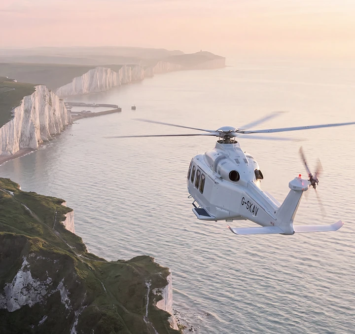 Helicopter flying over the coastline with white cliffs